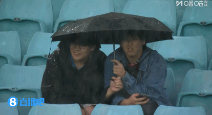 冒雨支持!国足比赛当地时间17点开球,球迷现场观战撑伞看球